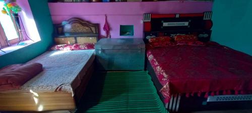 um quarto com 2 camas individuais e uma janela em Deep Jyoti Home stay em Bāgeshwar