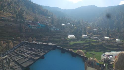 uma vista para uma aldeia nas montanhas com um edifício azul em Deep Jyoti Home stay em Bāgeshwar