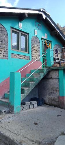 um edifício azul com escadas em frente em Deep Jyoti Home stay em Bāgeshwar