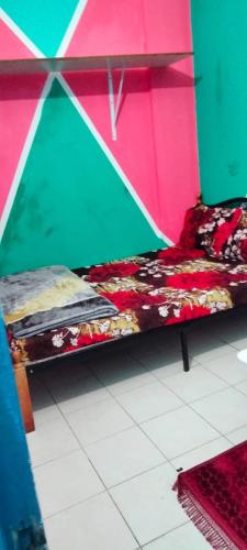 a bed in a room with a pink and green wall at Burjuman Metro just opp Partition room - 10 in Dubai