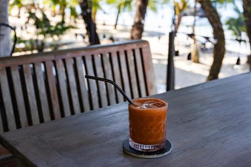 a drink is sitting on a wooden table at Barefoot Project formerly Baan Klong Kleng in Ko Phayam