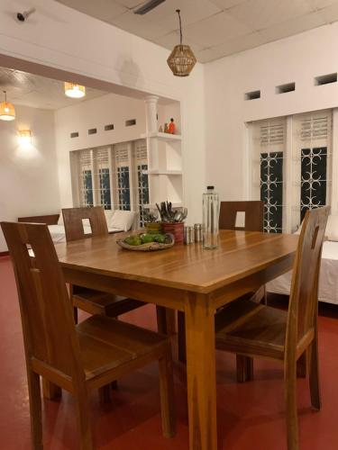 a dining room with a wooden table and chairs at Unrushed Midigama in Midigama