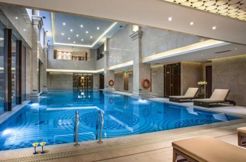 uma grande piscina no átrio do hotel em Lv Shou Hotel em Xangai