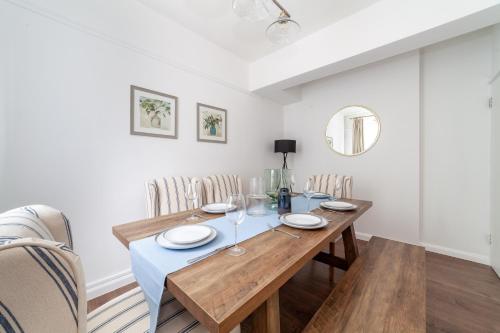 Spacious 3BR house wbalcony, South London في لندن: غرفة طعام مع طاولة وكراسي خشبية