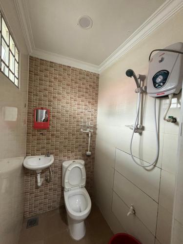 a bathroom with a toilet and a sink at Embun Selasih Homestay in Pasir Gudang
