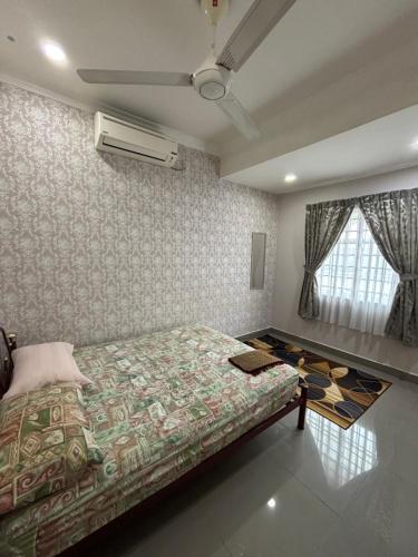 a bedroom with a bed and a fan and a window at Embun Selasih Homestay in Pasir Gudang