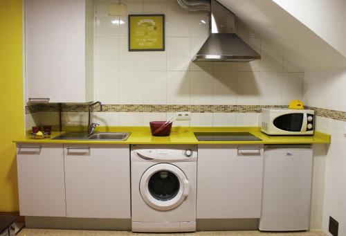 una cocina con lavadora y microondas en Apartamentos Vino y Camino, en Nájera