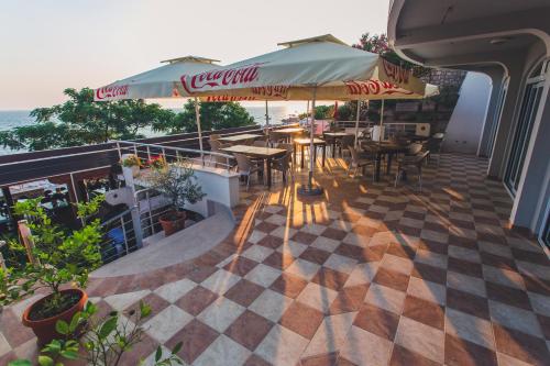 un ristorante con tavoli e ombrelloni su un balcone di Apartments Deus a Dobra Voda