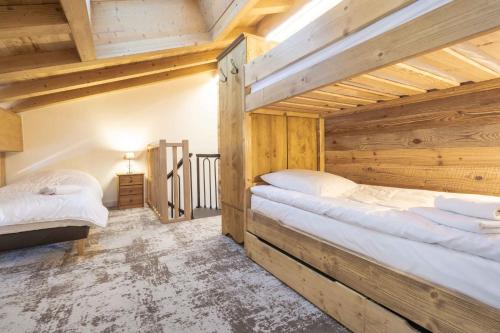 two beds in a room with wooden ceilings at Chalet la Parrachée in Lanslebourg-Mont-Cenis