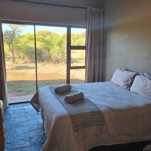 ein Schlafzimmer mit einem Bett mit zwei Handtüchern darauf in der Unterkunft Makhato Bush Lodge 114 in Bela-Bela