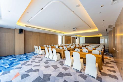 a conference room with rows of tables and white chairs at Holiday Inn Express Suzhou Bay by IHG in Suzhou