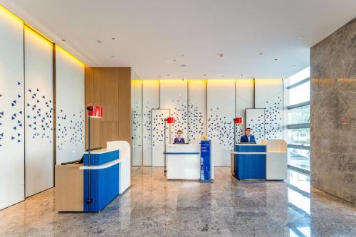 two people sitting at desks in a lobby at Holiday Inn Express Suzhou Bay by IHG in Suzhou