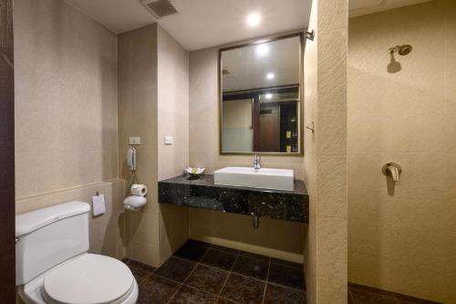 a bathroom with a toilet and a sink and a mirror at Patong Lodge Hotel - SHA Extra Plus in Patong Beach
