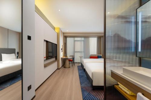 a hotel room with two beds and a tv at Holiday Inn Express Suzhou Bay, an IHG Hotel in Suzhou