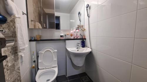 a small bathroom with a toilet and a sink at Yolo House in Incheon