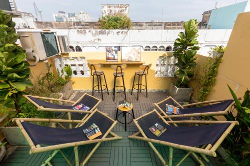 une rangée de chaises et de tables sur un balcon dans l'établissement Saigon Authentic Hostel - Cozy Rooftop, Family Cooking Experience, FREE Walking Tour, Vietnamese Breakfast & Gym, à Hô-Chi-Minh-Ville