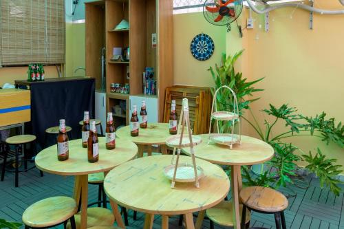 Habitación con mesas de madera y botellas. en Saigon Authentic Hostel - Cozy Rooftop, Family Cooking Experience, FREE Walking Tour, Vietnamese Breakfast & Gym, en Ho Chi Minh