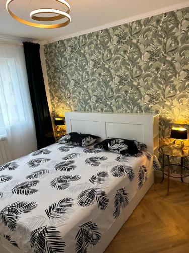 a bedroom with a bed with a black and white comforter at Alex Apartament Central in Bucharest