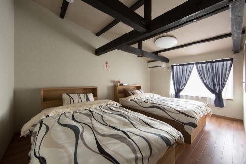 - une chambre avec 2 lits et une fenêtre dans l'établissement Kyoto Gion Shinbashi-an, à Kyoto
