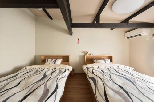 two beds sitting in a room with at Kyoto Gion Shinbashi-an in Kyoto