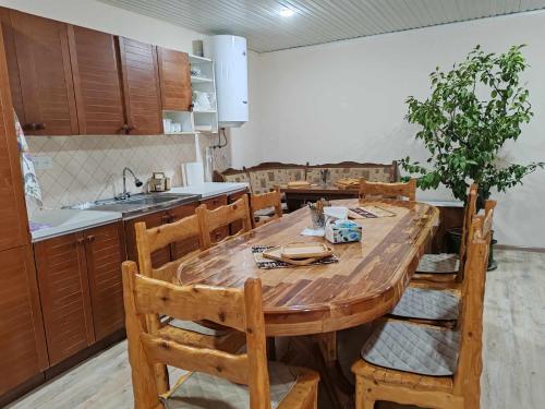 een keuken met een houten tafel en houten stoelen bij Sun House in Jechegnadzor