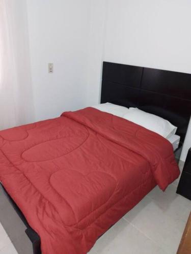 a red bed with a black headboard and a red blanket at Mountain view apartment in Makadi Heights in Hurghada