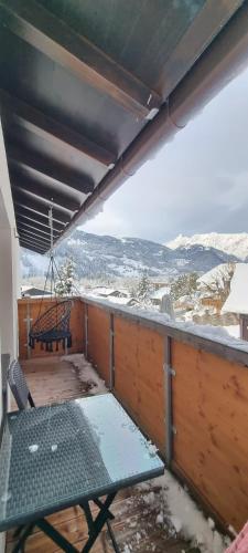 a balcony with a table and a swing and snow at Haus Tisch in Schruns-Tschagguns
