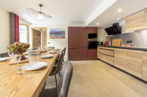 une cuisine et une salle à manger avec une grande table et des chaises en bois dans l'établissement Chalet La Turra, Spa privée, à Lanslebourg-Mont-Cenis