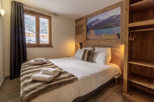 a bedroom with a bed with towels on it at Chalet La Turra, Spa privée in Lanslebourg-Mont-Cenis