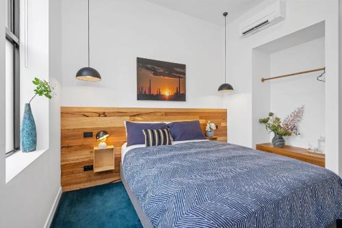 a bedroom with a bed with a wooden headboard at The Electric Hotel in Geelong