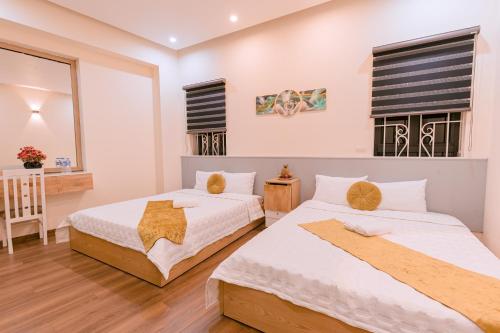 1 dormitorio con 2 camas y mesa en Golden Diamond Hotel en Hanói