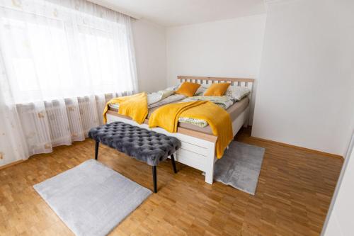 a bedroom with a bed and a bench and a window at Wohnung am Stadtrand in Salzburg