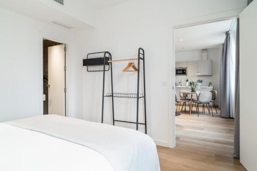 - une chambre avec un lit blanc et une salle à manger dans l'établissement limehome Sevilla Calle Granada, à Séville