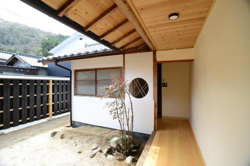 a home with a wooden ceiling and a patio at 北房まちの駅 ゲストハウス in Maniwa