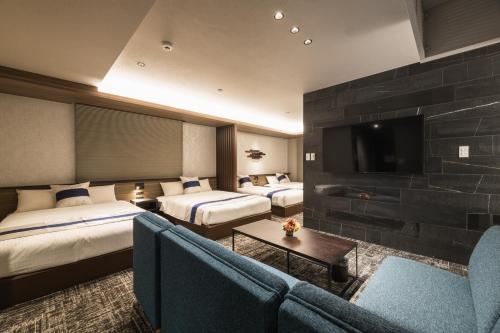 a hotel room with two beds and a flat screen tv at GRAND BASE Kagoshima Tenmonkan in Kagoshima
