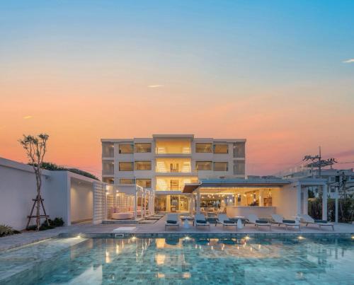 un hotel con piscina frente a un edificio en U Hua Hin en Phetchaburi