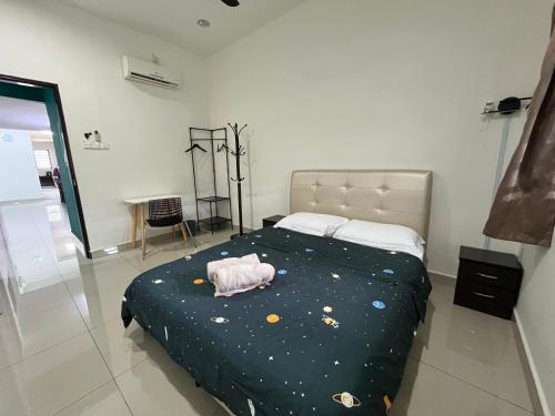 a bedroom with a bed with a stuffed animal on it at Green Space Homestay Cozy Family(8-12pax) in Ipoh