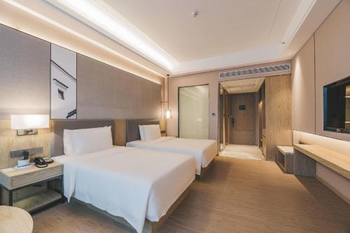 a hotel room with two beds and a television at Atour Hotel Shenzhen Xili Innovation Valley in Shenzhen