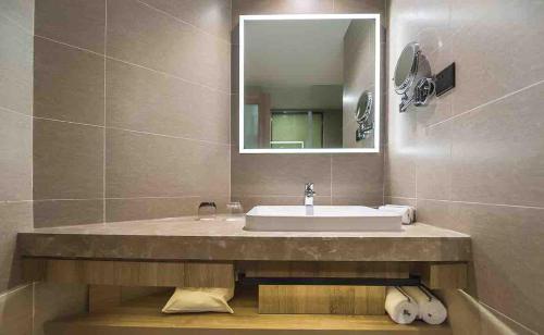 y baño con lavabo y espejo. en Atour Hotel Hailian Fuzhou, en Fuzhou
