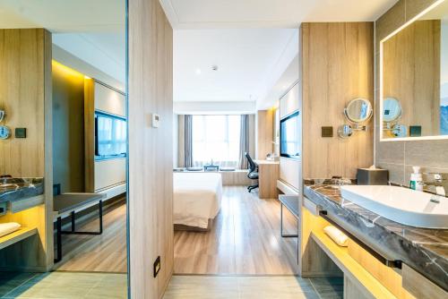a hotel bathroom with a bed and a sink at Atour Hotel Guiyang Convention and Exhibition Center in Guiyang
