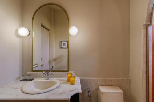 a bathroom with a sink and a mirror at Manuscript - Jhilwara Haveli in Udaipur