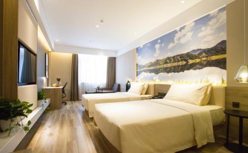 um quarto de hotel com duas camas e um quadro na parede em Atour Hotel Shenyang Hunnan Olympic Sports Center em Shenyang