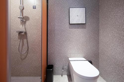 a bathroom with a shower and a toilet and a picture at Atour S Hotel Shenzhen Futian Port in Shenzhen