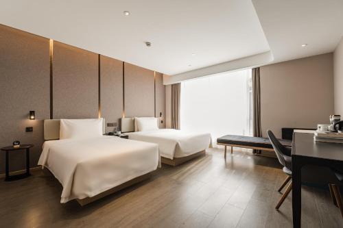 Pokój hotelowy z 2 łóżkami i biurkiem w obiekcie Atour Hotel Hangzhou Xiaoshan Airport w mieście Xiaoshan