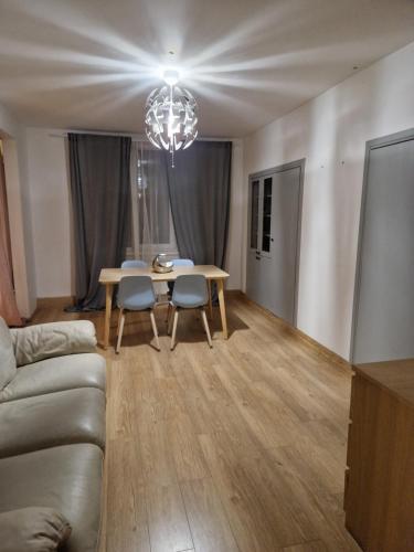 uma sala de estar com uma mesa e cadeiras e um lustre em Studio dzīvoklis/māja em Cēsis