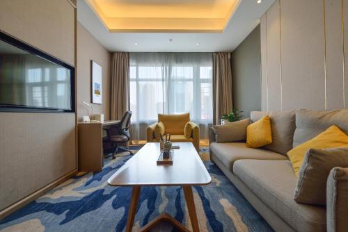a living room with a couch and a table at Atour Hotel Railway Station Dalian in Dalian