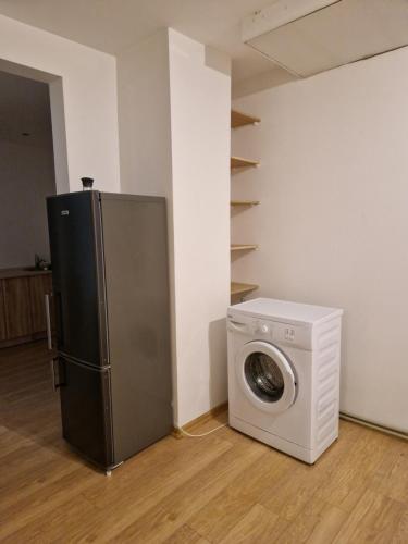 uma cozinha com um frigorífico e uma máquina de lavar roupa em Studio dzīvoklis/māja em Cēsis