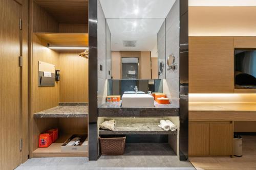 ein Badezimmer mit einem Waschbecken und einer Theke mit einem Waschbecken in der Unterkunft Atour X Hotel Beijing Sanyuan Bridge in Peking
