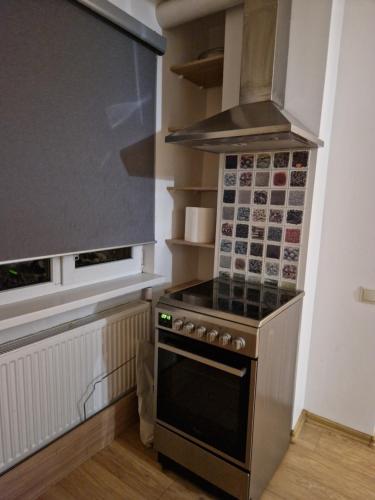 uma pequena cozinha com fogão e micro-ondas em Studio dzīvoklis/māja em Cēsis