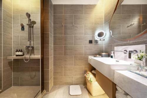 uma casa de banho com um lavatório e um chuveiro em Atour Hotel Kunming West Renmin Road Daguan em Kunming